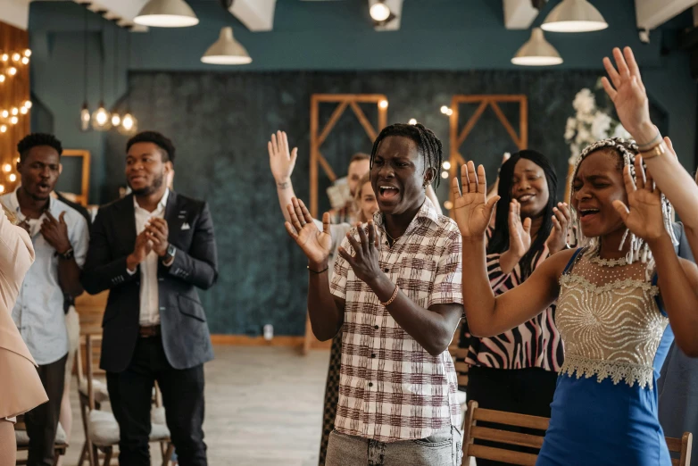 several people standing and clapping in a room