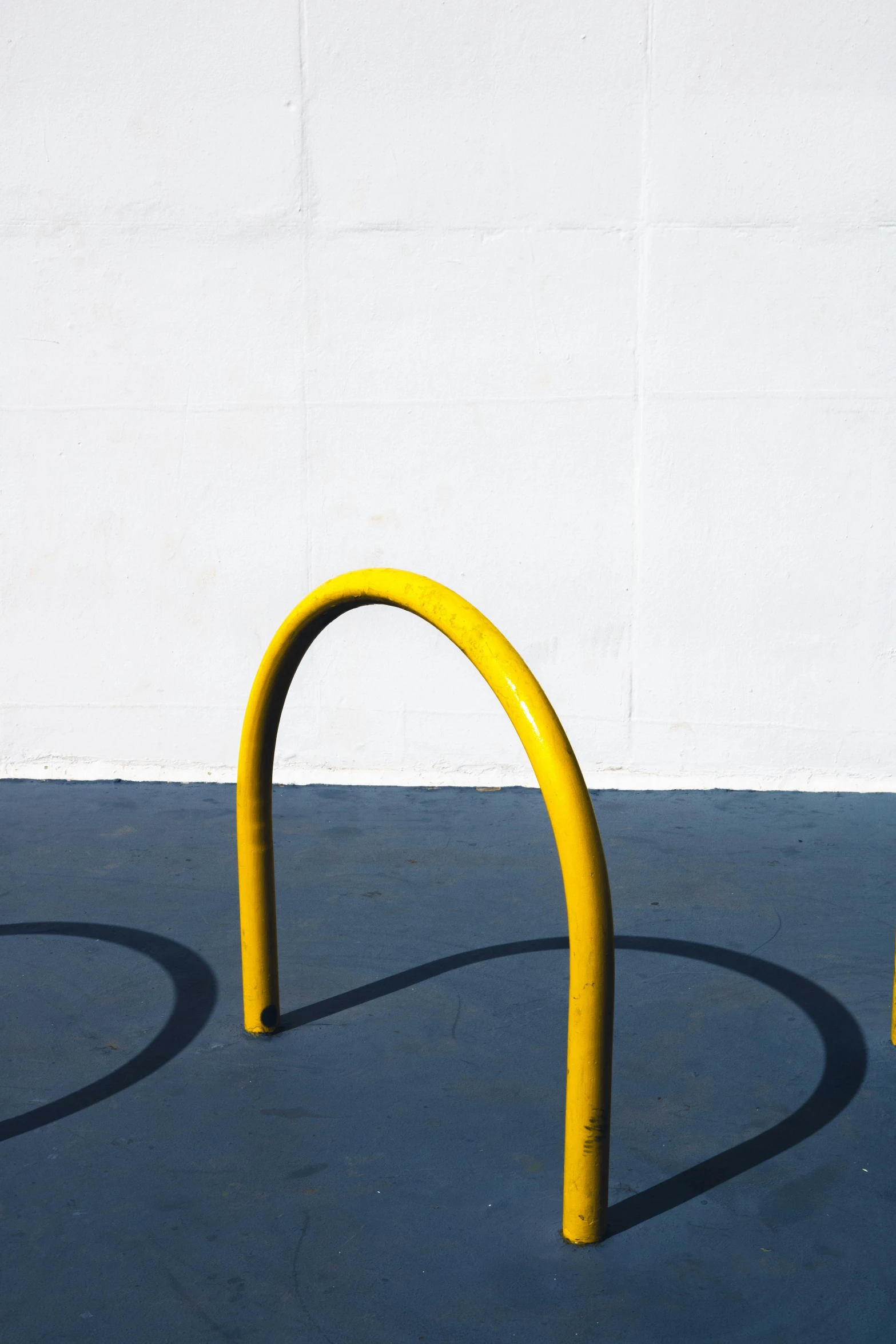 two yellow poles sitting side by side against a wall