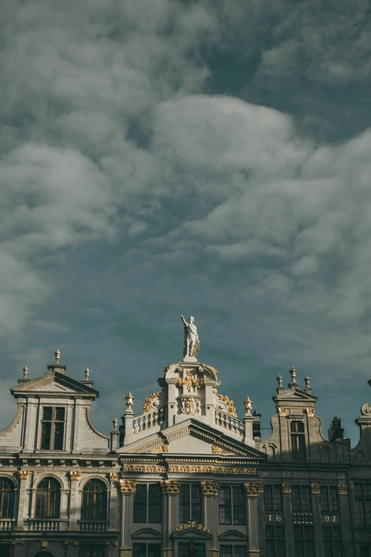 the large building has statues on it's roof