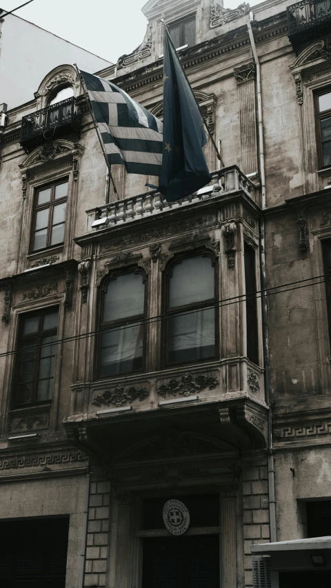 the flag is flying in front of an old building