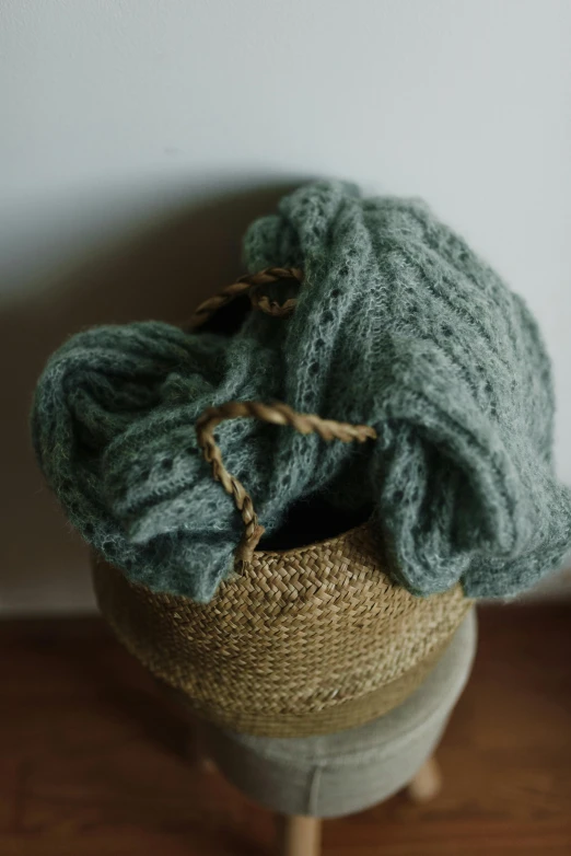 green knitted hat sitting on top of a wooden stand