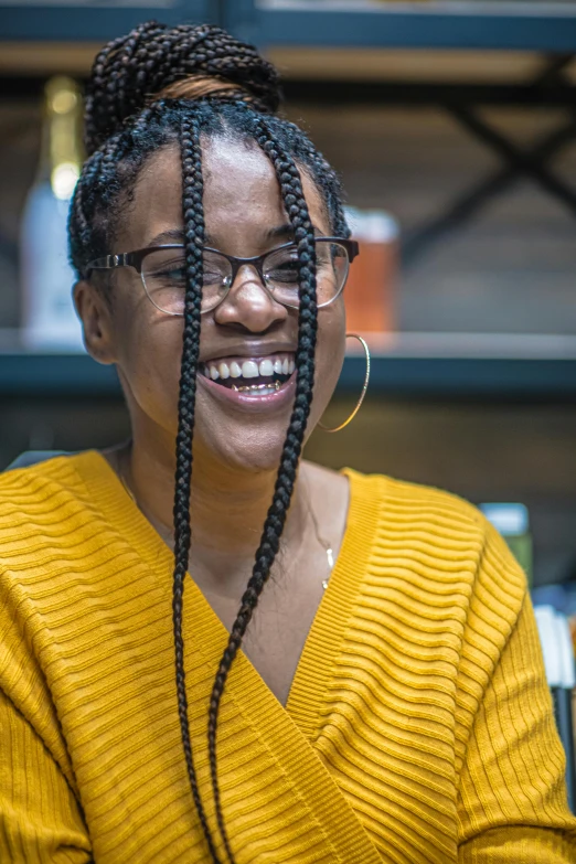 a woman with long ids wearing a yellow sweater