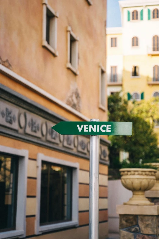 a green street sign sitting in front of tall buildings