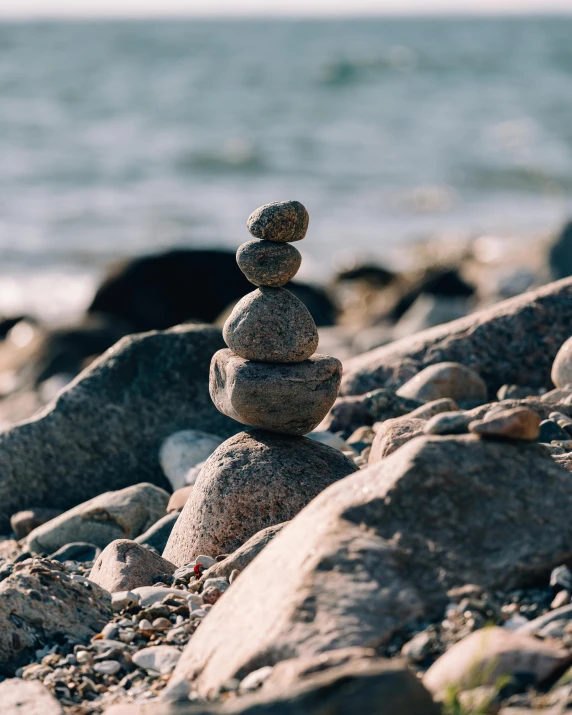 pile of rocks on the beach by water