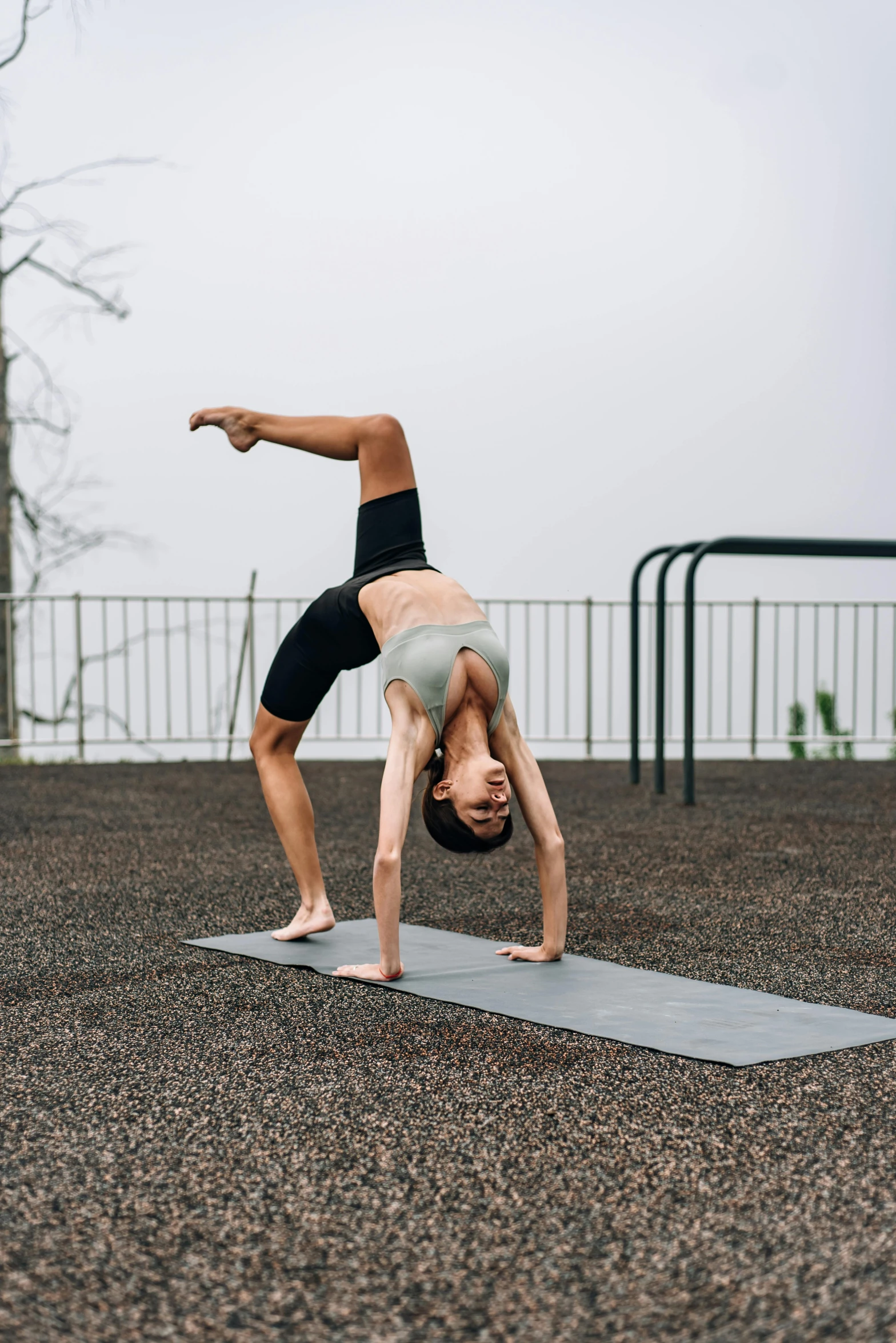 a woman doing a back stand on her yoga mat