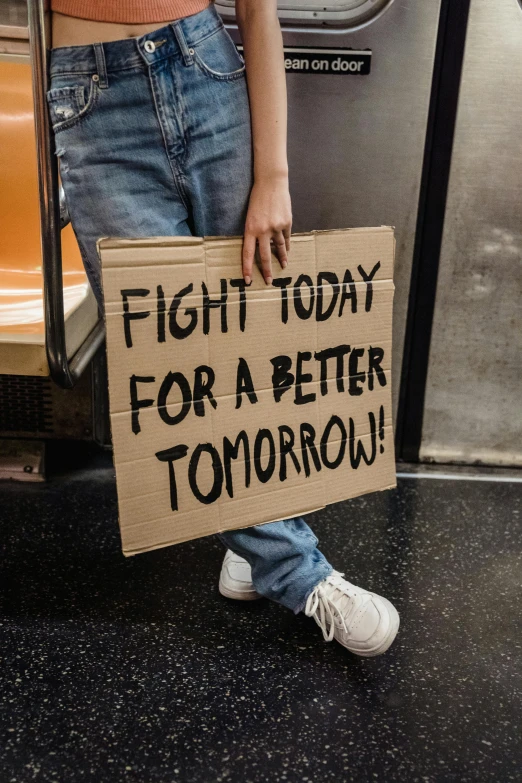 the woman holds a sign that reads fight today for a better tomorrow