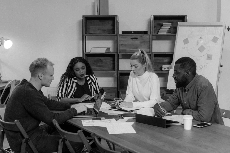 a group of people sitting around a table having a discussion