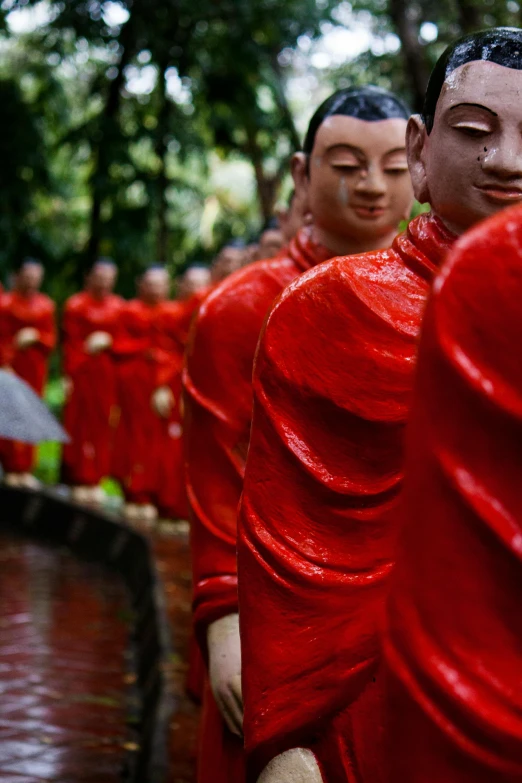 several statues standing side by side with trees in the background