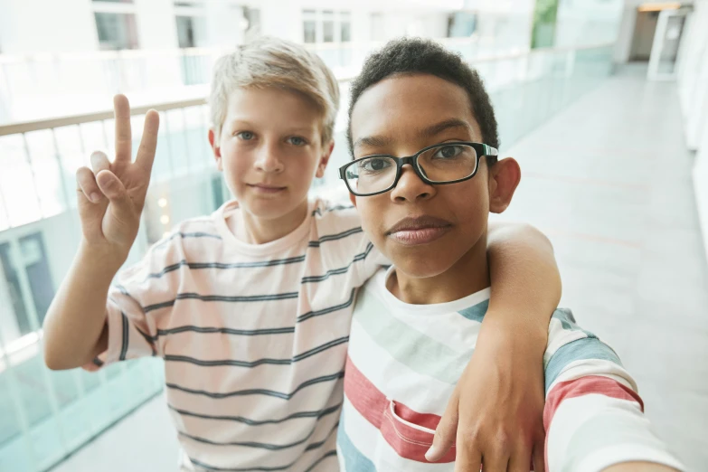 two boys are posing for the camera while making the peace sign