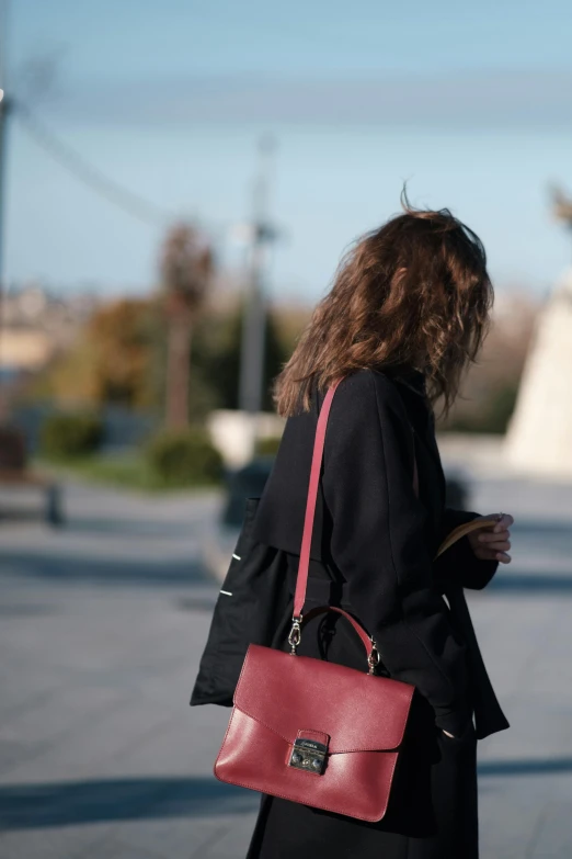 a person wearing black and holding a pink purse