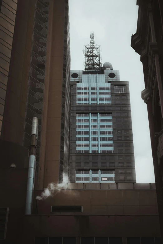 a tall building with several windows near a few buildings