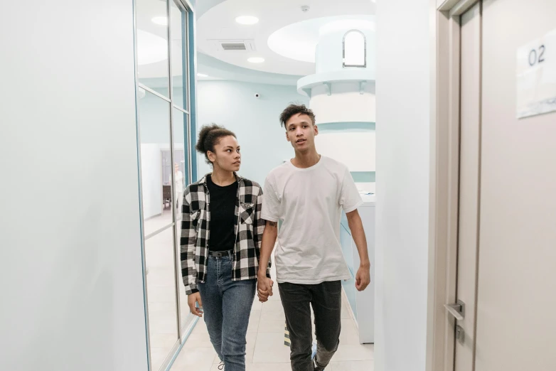 a man and a woman are walking through the building