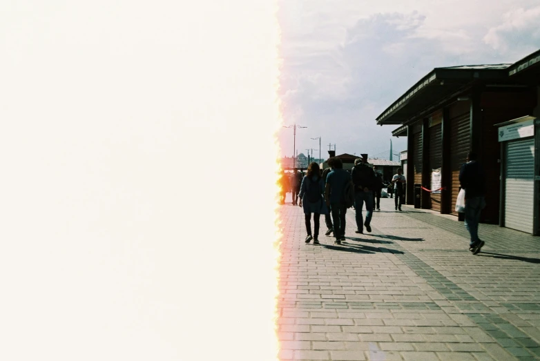 several people walking on the sidewalk near a building