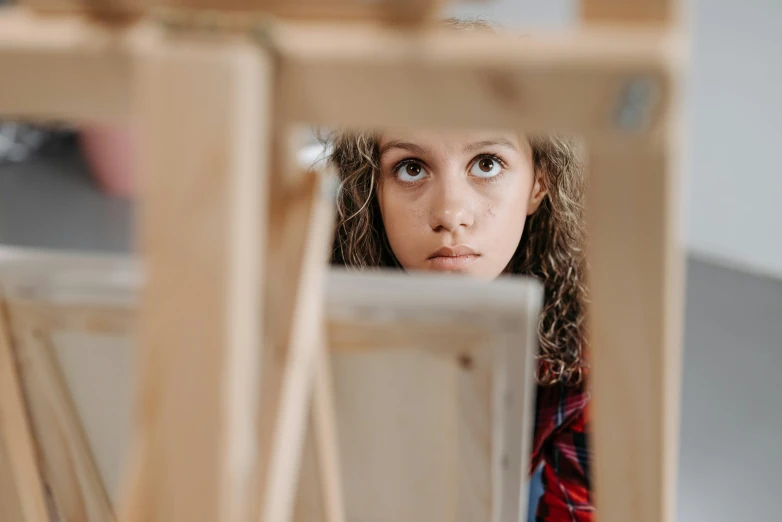 a girl looking at some chairs in the back