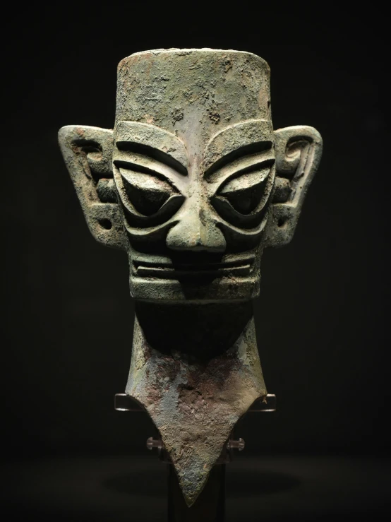 a stone face mask that is standing on display