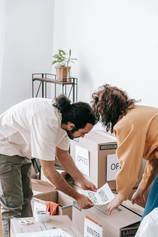 two people packing boxes on top of each other