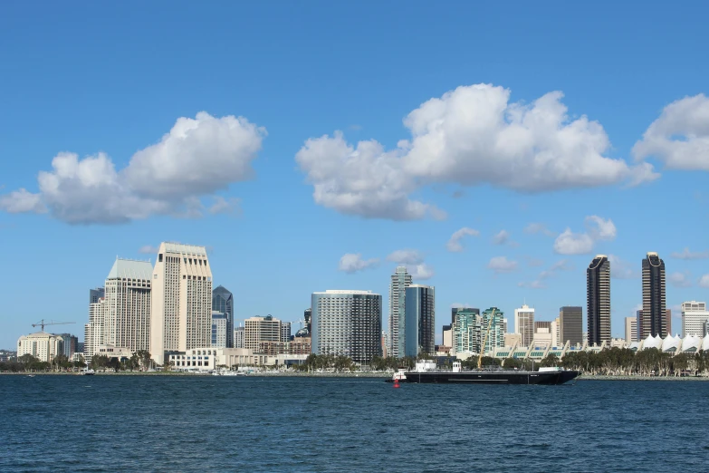 a view of an ocean, with a large boat in the water, with some buildings around it