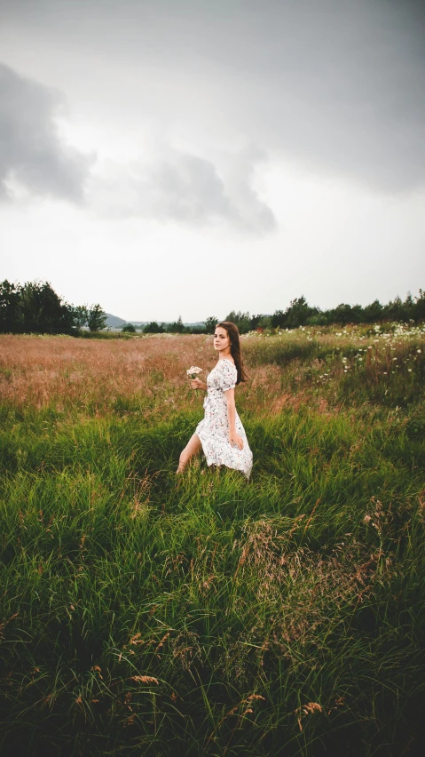 a woman walking through a lush green field