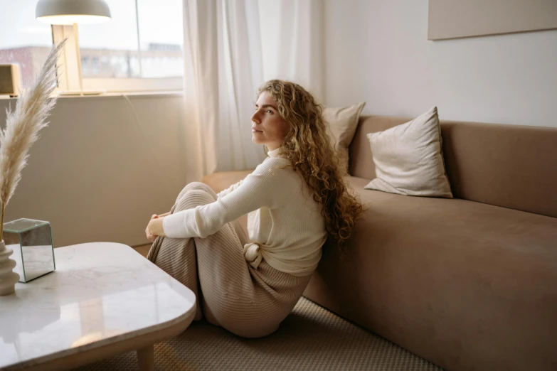 a woman sitting on the couch and staring outside