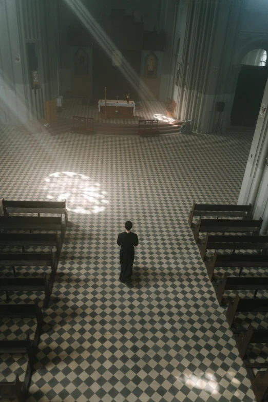 a church filled with pews next to a woman in a black suit