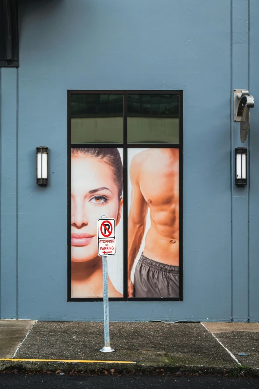 a blue building with two signs in it and an advertit on the door