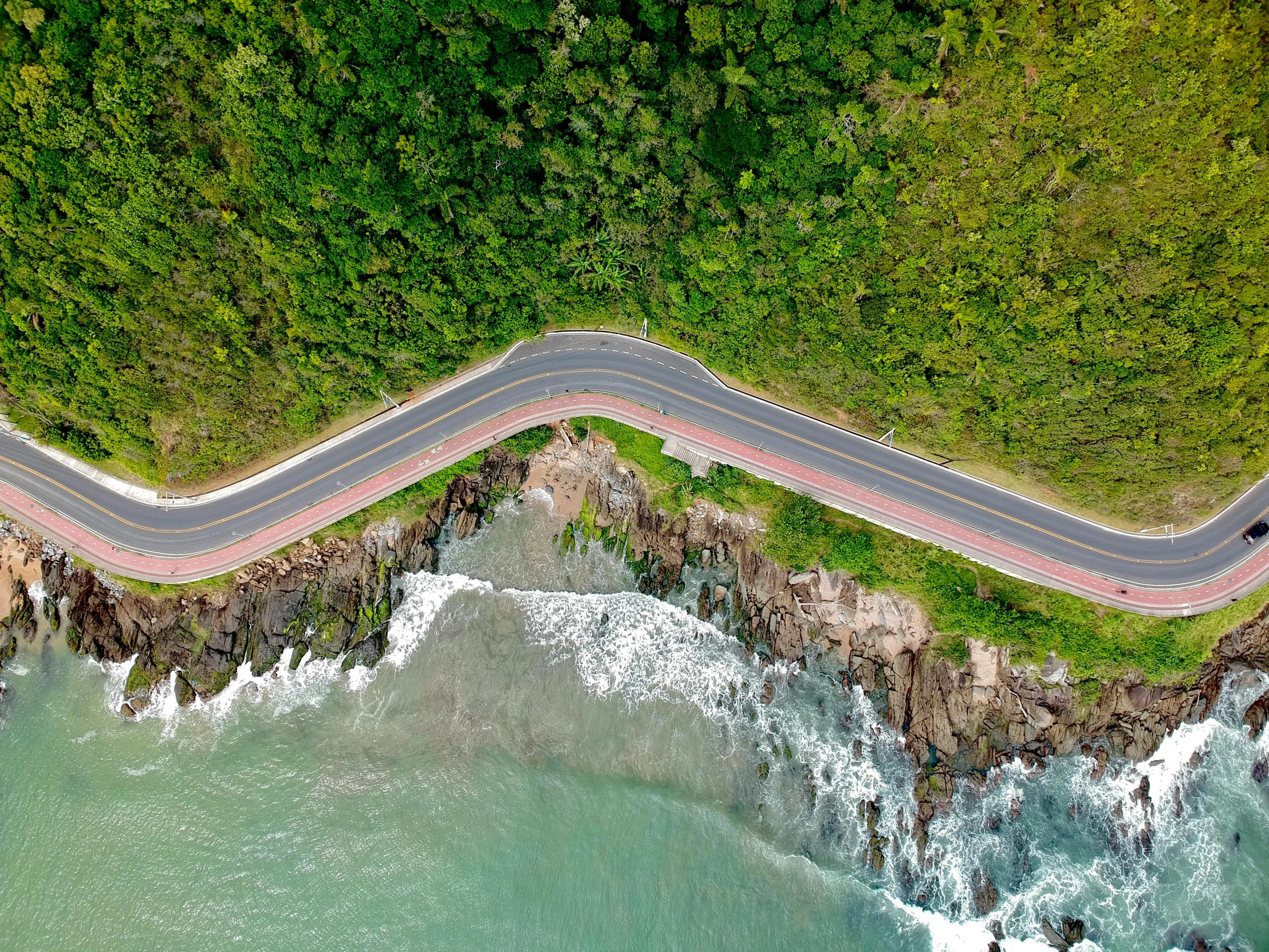 an aerial view of a road and the ocean