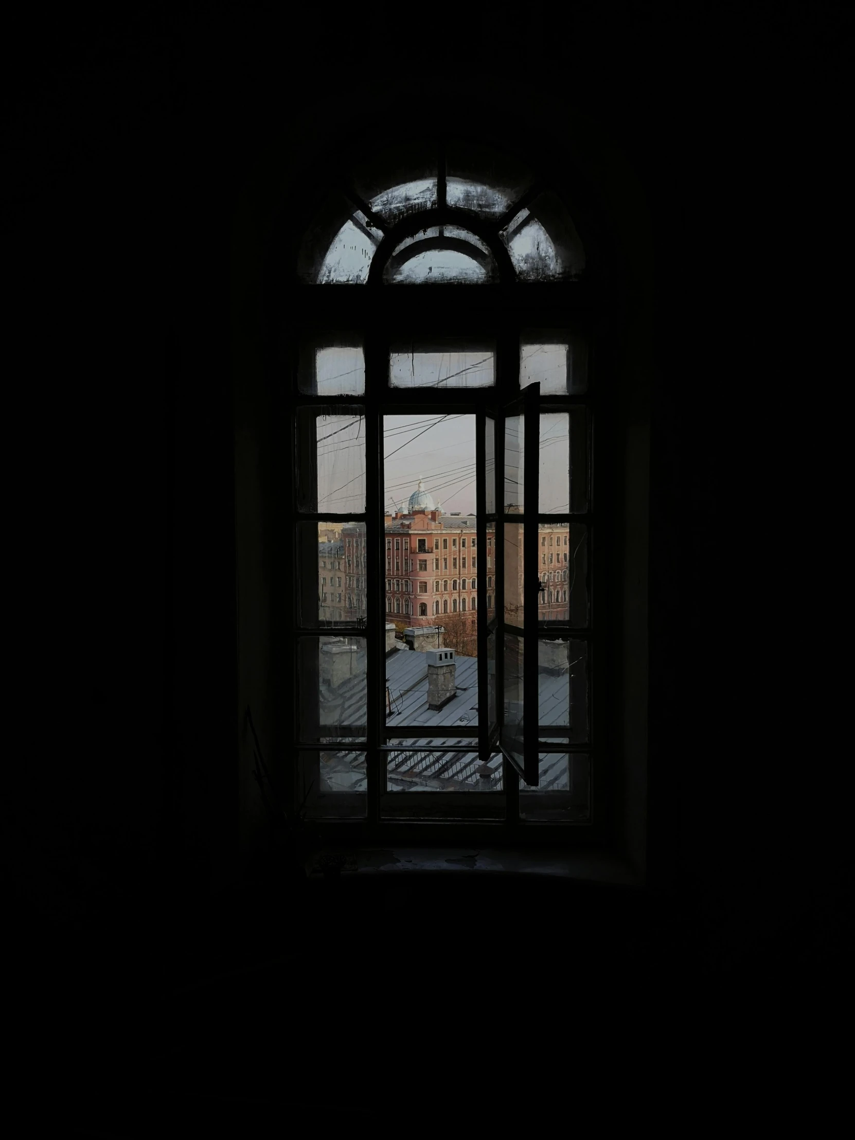 open door in dark room with city building through glass