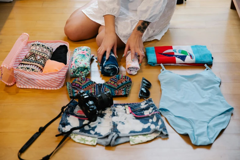 a woman sitting on the ground with many items in her purse