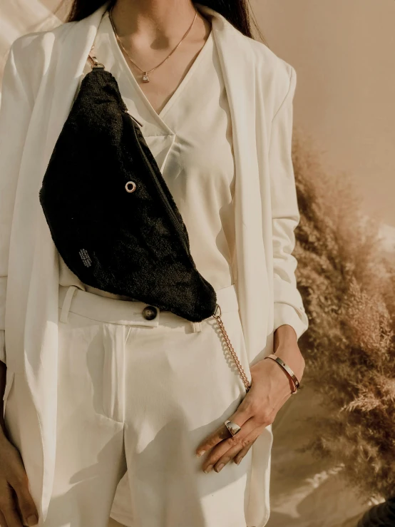 a woman wearing a white suit holding her purse