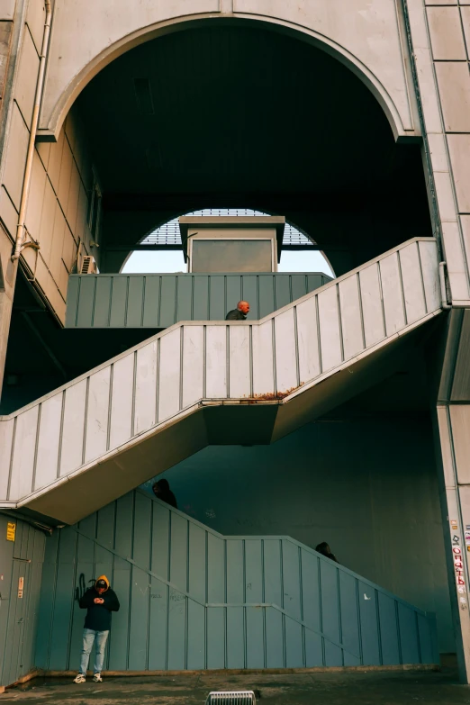 two people standing on an outside stairway next to a building