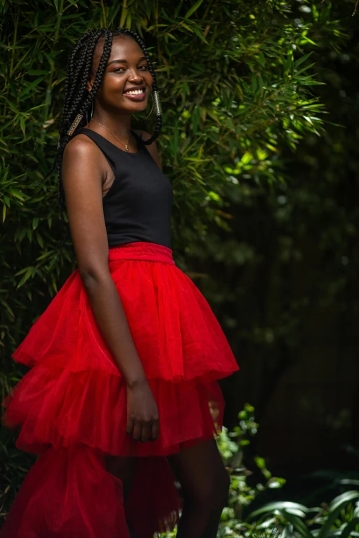 the woman is smiling wearing a red skirt