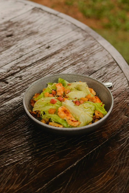 a bowl of food on top of a wooden table