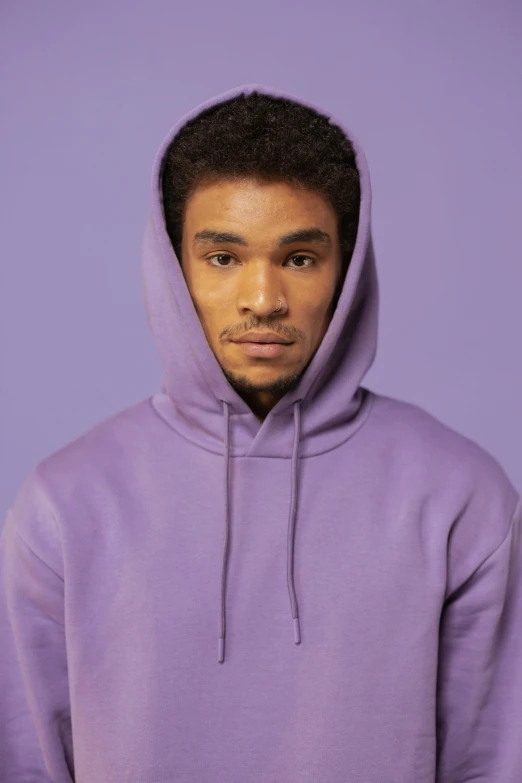 a young man wearing a purple hoodie poses for a po