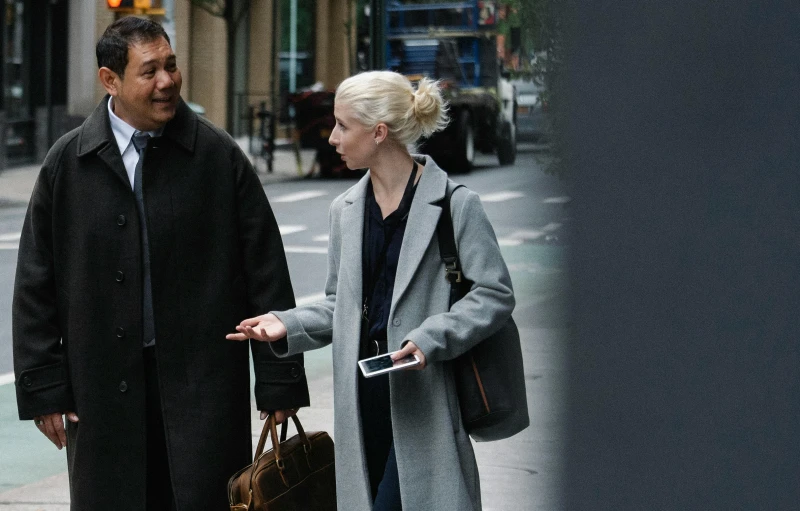 a man and woman talk on a city street