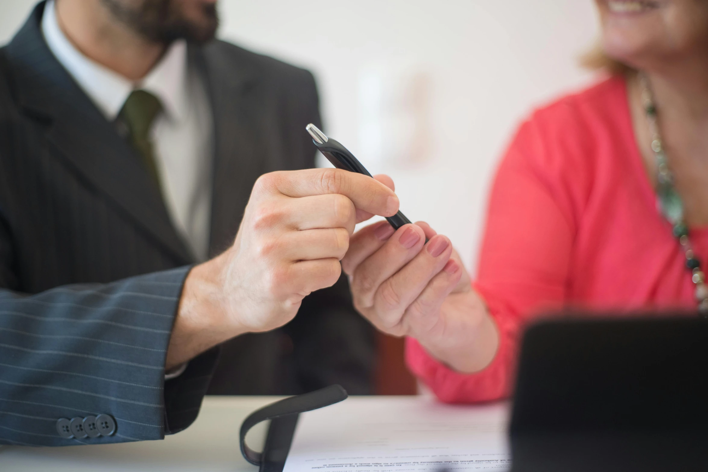 a man in a business suit writing on paper