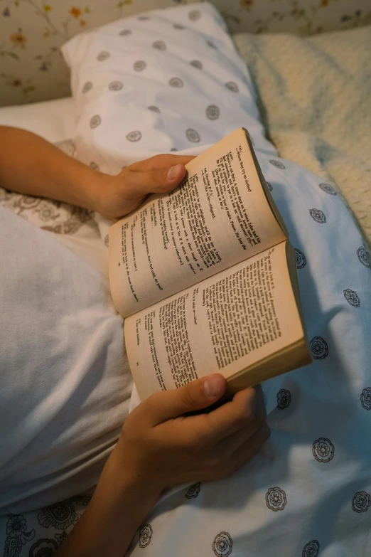 woman in bed with two books in her hands