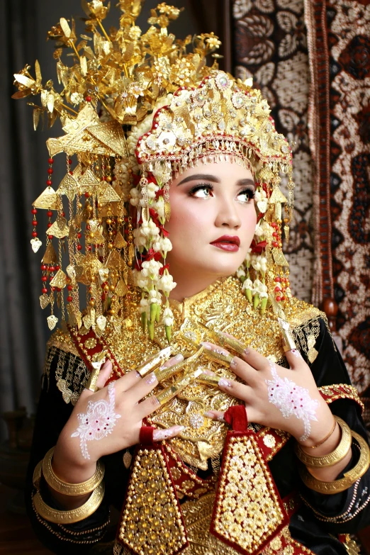 a beautiful young lady in oriental dress holding gold ornaments