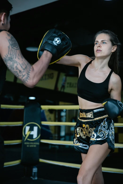 a woman is wearing black and holding up her glove