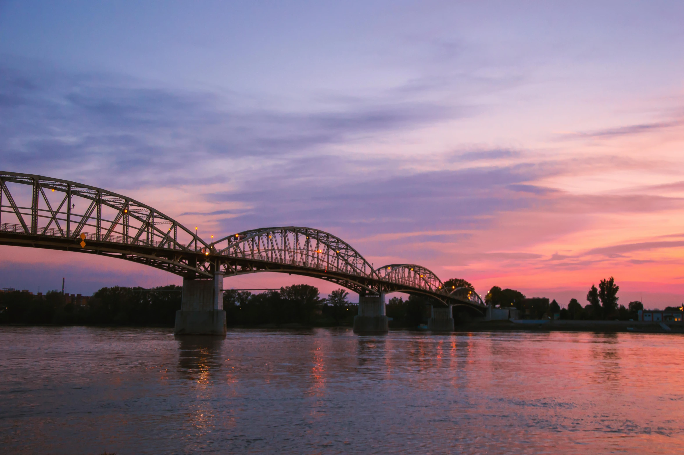 a large bridge spanning over a river at sunset