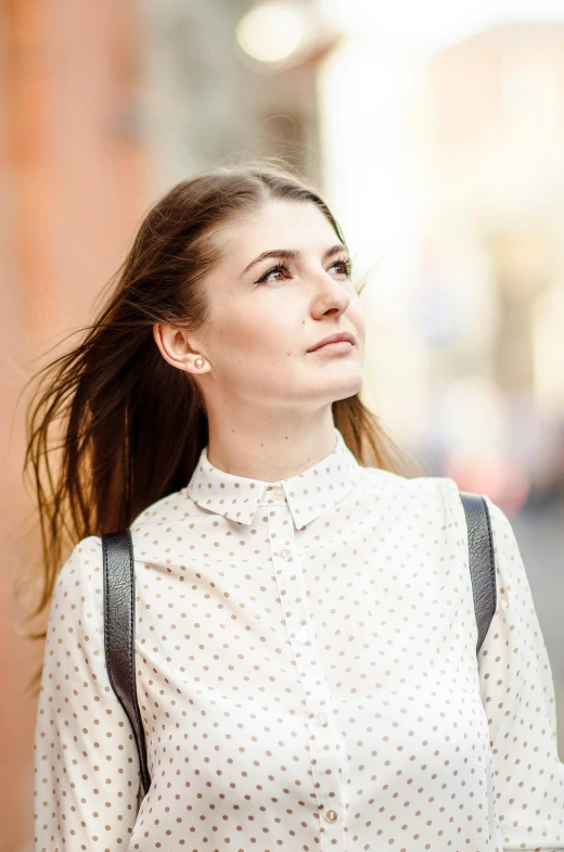 a woman standing in the street wearing an old fashion polka dotted blouse