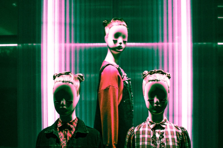 three children standing in front of a wall wearing their heads as they both look down at soing