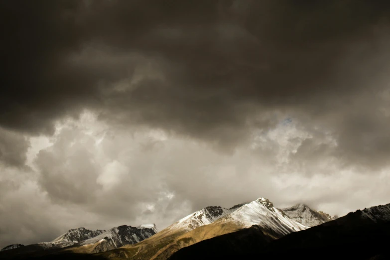 a mountain range under a cloudy sky