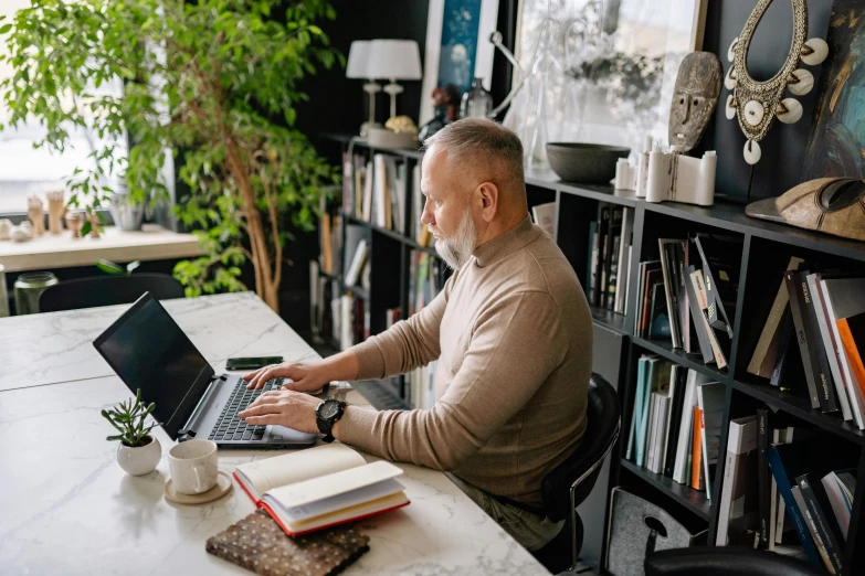 a man sitting at a table using a laptop computer