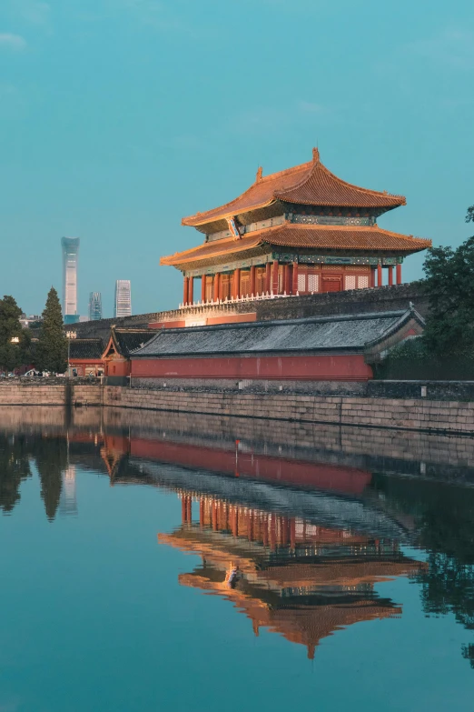 an oriental structure in the distance with the sky reflecting off it