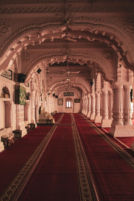 a very long room with red carpets and rugs