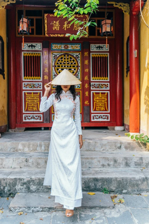 a woman is standing in front of an asian doorway