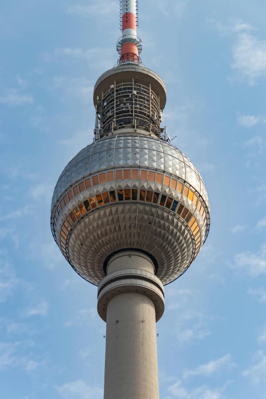 the berlin tv tower against the sky with some clouds