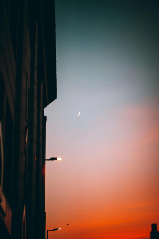 a plane flies over some buildings and street lights