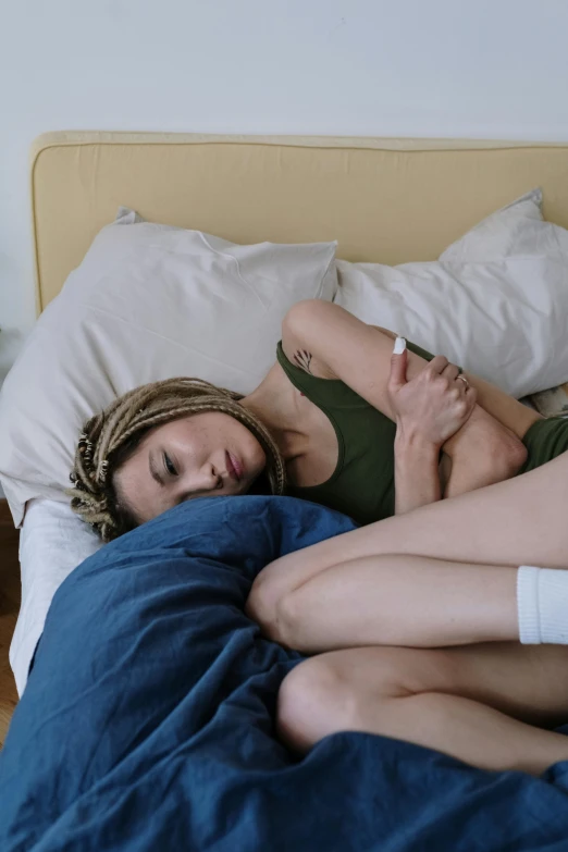 two women cuddling on a bed with pillows