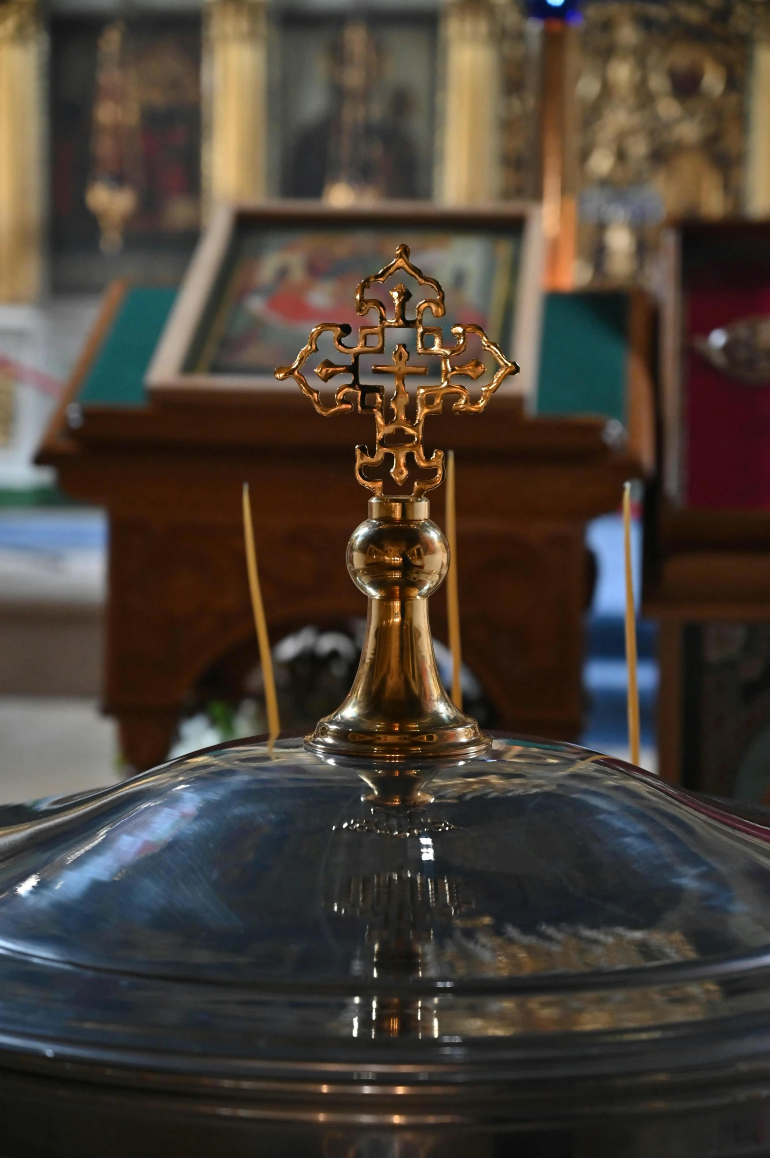 a metal chalice with a cross on it